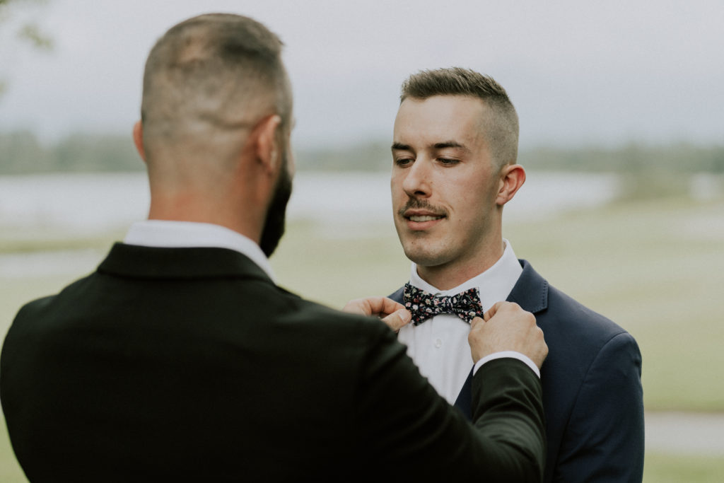 a good friend fixing the grooms bowtie before the ceremony