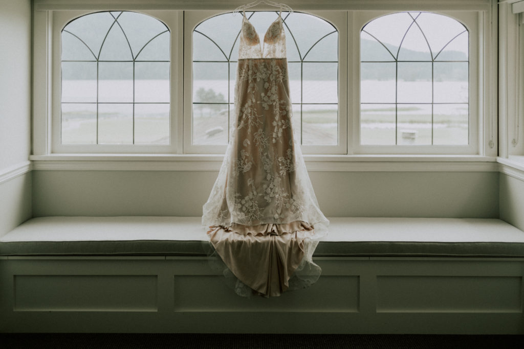 Brides dress hanging in the upper floor windows of the main cottage at rowena's Inn.